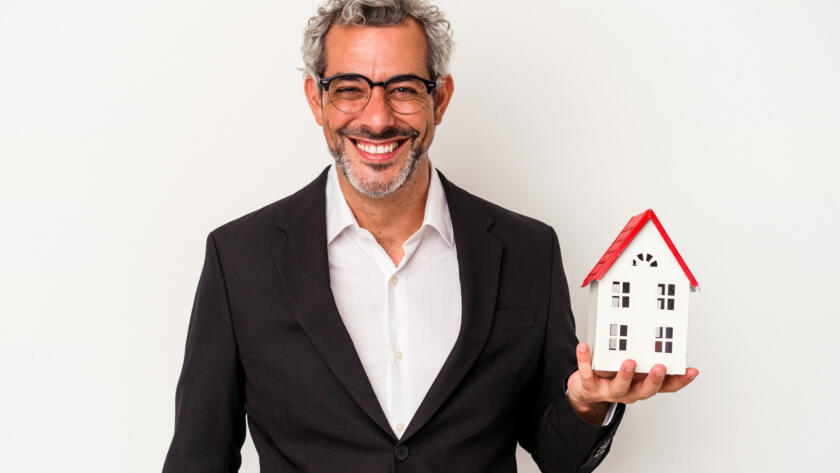middle age business man holding bills house model isolated blue background happy smiling cheerful &raquo; StayBooked