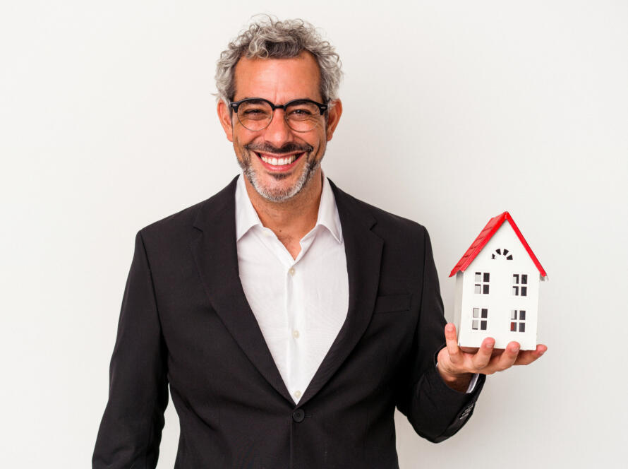 middle age business man holding bills house model isolated blue background happy smiling cheerful » StayBooked